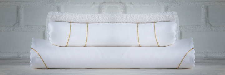 Luxury white bed sheets stacked on loft background. Closeup.