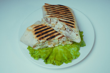 Shaurma grilled with chicken, French fries on a salad leaf. fast food