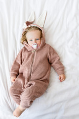 Innocent toddler in jumper on bedding