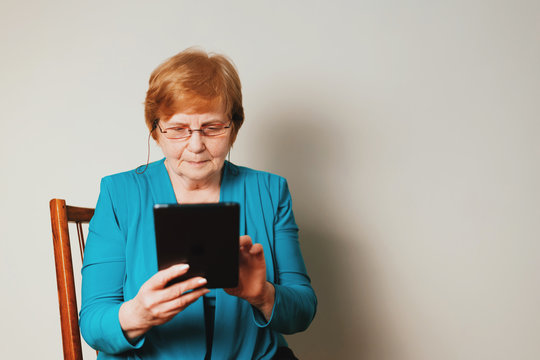 Old woman's hands holding a tablet