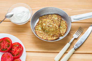 Fried zucchini fritters with salad on a plate