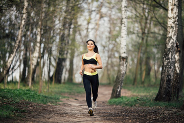 Pretty young girl weat in training clothes running in the park