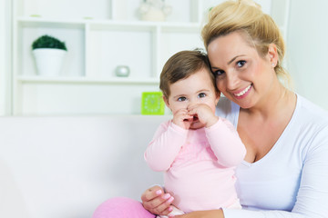 Portrait of smiling mother and  little baby girl in her arms.Copy space, shallow doff