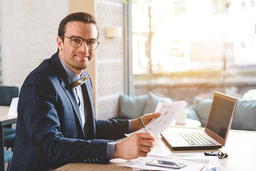 Cheerful male writing on paper at table