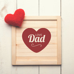 Happy fathers day sign with heart on wooden background.