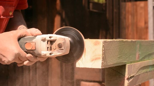 Holzbalken wird mit Schleifmaschine angepasst