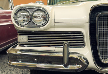 Detail of the front headlight of an old car in garage