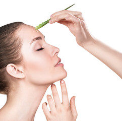 Young woman uses aloe vera oil for skin.