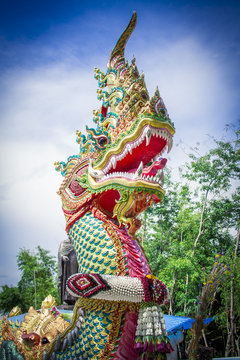 Head of naga statue image in Thai temple with blue sky background