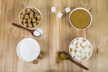 Different kind of white and brown sugar on old brown table
