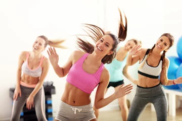 Poster Gruppe glücklicher Menschen mit Trainertanzen im Fitnessstudio © Kalim