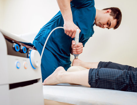 Shock wave therapy. The magnetic field, rehabilitation. Physiotherapist doctor performs surgery on a patient's heel