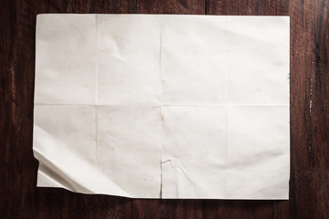 Vintage broken empty folded and crumpled paper on dark wooden table