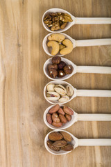 Nuts in a wooden spoons on a  wooden table
