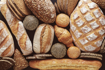Bread background, top view of white, black and rye loaves