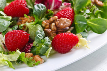 Green vegan salad with raspberry and nuts