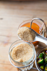 Thai style Seasoning, fish sauce, sugar, vinegar and chilli powder in glasses and aluminium cover on wooden brown table, street food restaurant