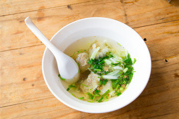 Wonton soup with spoon in a bowl. Traditional asian food