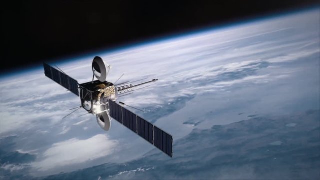 Communications satellite orbiting above earth transmitting a signal.