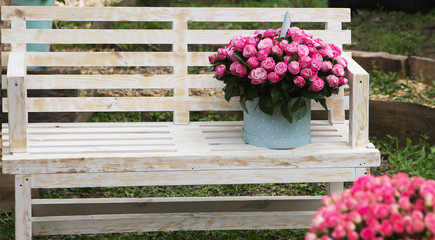 Beautiful bouquet of roses on wooden bench. Outdoors.