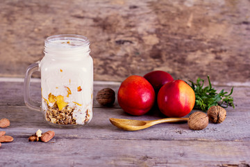 Granola with natural yoghurt, peaches and nuts
