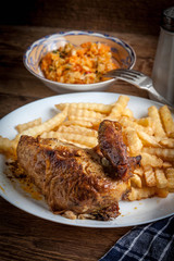 Roasted chicken with french fries on a plate.