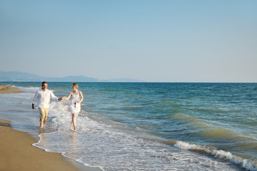 Happy couple running on the beach