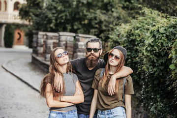 man hugging two pretty girls