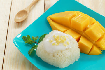 mango and sticky rice on wood background.