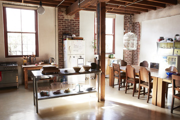 Serving table and dining area in open plan loft apartment