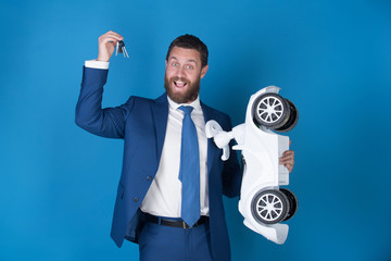 happy man wearing suit with white toy car, keys