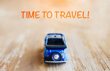 Toy vintage cabrio car on wooden background, travel motivation