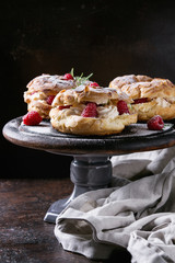 Homemade choux pastry cake Paris Brest with raspberries, almond and rosemary, served on black...