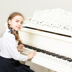 A girl from a music school plays the piano.
