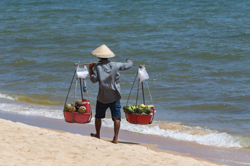 Vietnamese man  selling fruits on the  beach. Vietnam