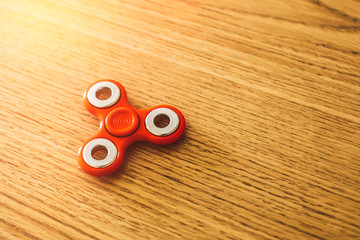 Red spinner gadget over wooden table.