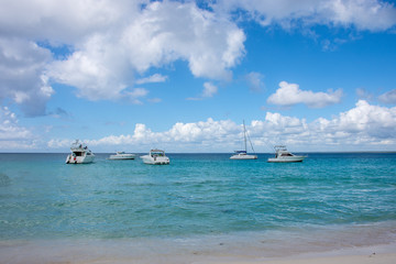 White high-speed boats stand on the bank of the Caribbean Sea, overlooking a beautiful sky with white clouds