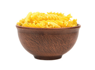 Uncooked pasta fusilli in a bowl on white background