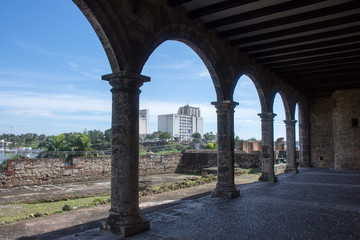 View of the city through the arches of an old house with a blue sky