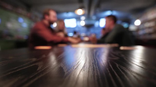 men drink beer at a bar, blurred background