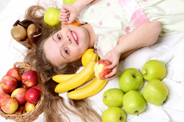 Fototapeta na wymiar child, cute baby girl laying with colorful fruits in basket