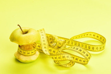Apple wrapped by yellow measure tape