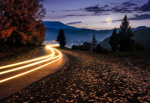 countryside road with car lights at night