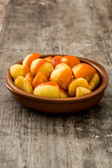 Patatas bravas in bowl on wooden table

