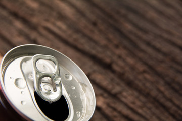 Top of an iron can. Can with a drink of cola on wooden background