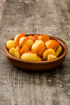 Patatas bravas in bowl on wooden table

