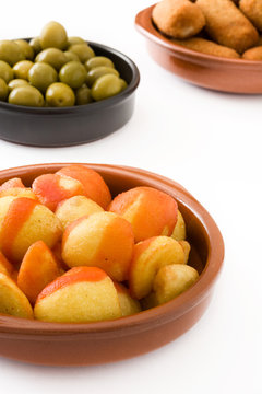 Traditional spanish tapas. Croquettes, olives and patatas bravas isolated on white background

