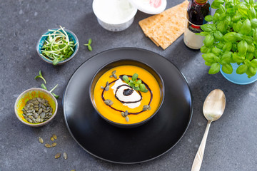 Homemade Paleo Pumpkin Soup with Coconut Milk on Dark Background, Horizontal View