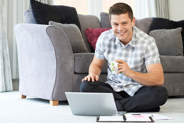 Portrait Of Male Freelance Worker Using Laptop At Home