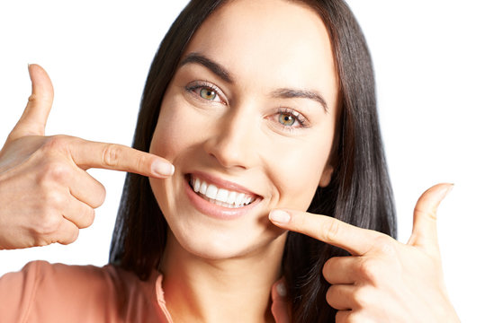 Attractive Woman Pointing To Her Smile With Perfect White Teeth
